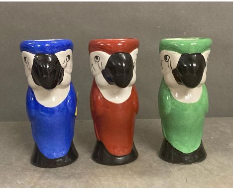 Three ceramic parrot themed vases one red, one blue and one green
