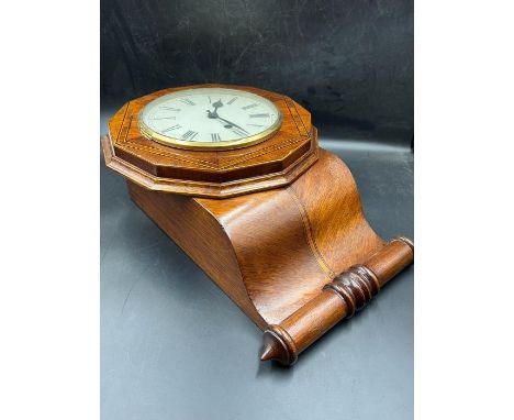 An inlaid wall clock with scrolling end