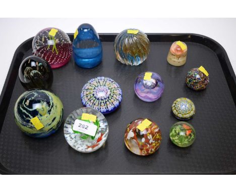 A selection of coloured glass paperweights, including: a Caithness Polka paperweight; a Caithness Optix paperweight; and othe