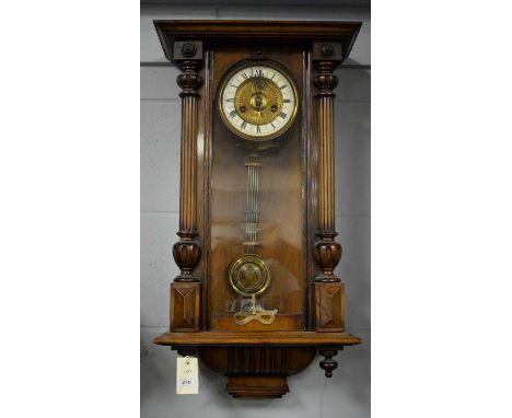 A Vienna walnut and beech wall clock, circa 1900, with enamelled roman dial and bi-metallic pendulum, with key, 65 x 35cms.