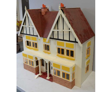 A two-storey half-timbered doll's townhouse, with lower-storey double-bay windows and pillared porch, the removable one-piece