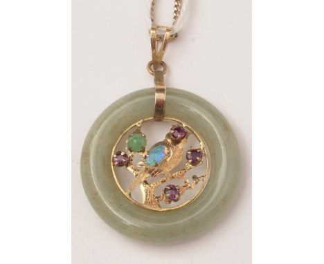 A jade coloured stone and gemstone pendant, the greenstone ring with 14ct yellow gold bird pattern mount set with red and gre