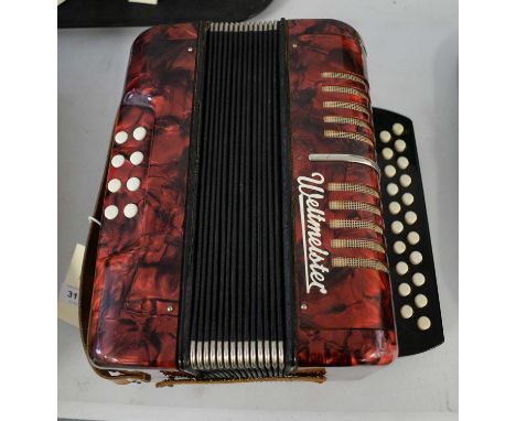 A 20th Century German Weltmeister accordion in shades of red and black.