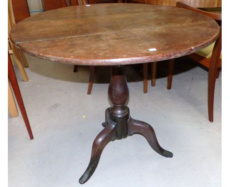 An 18th century snap top circular tripod table on turned baluster column