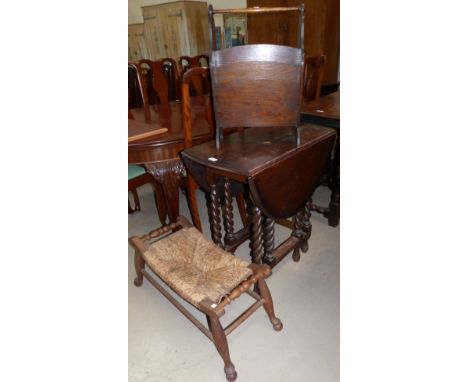 A drop leaf barley twist dining table; an oak magazine rack; an oak saddle stool