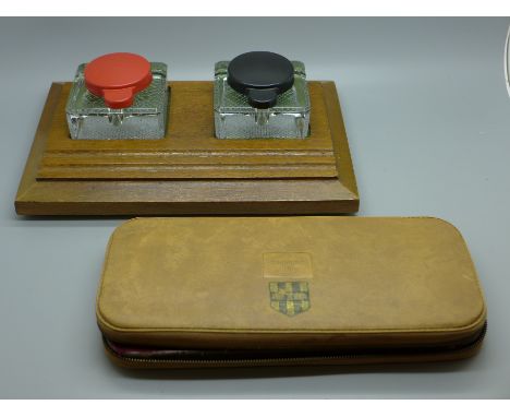 A wooden ink stand with twin glass inkwells and a geometry set 