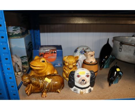 A quantity of money boxes together with Poole pottery dolphins