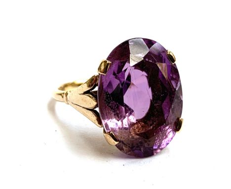 A 9ct gold ring set with a large oval amethyst, the stone 2cm long, size T 1/2, 8.3g 