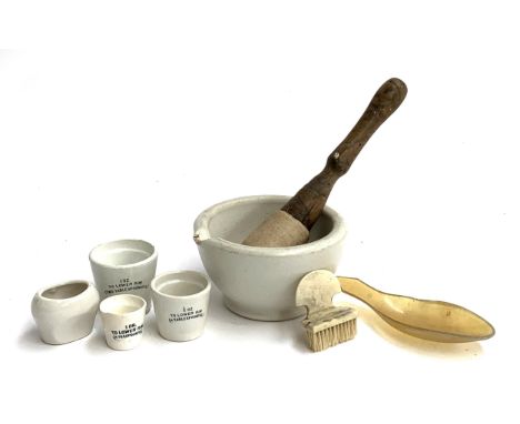 A small lot to include 19th century ivory nail brush, pestle and mortar, ceramic measures, eye bath etc 