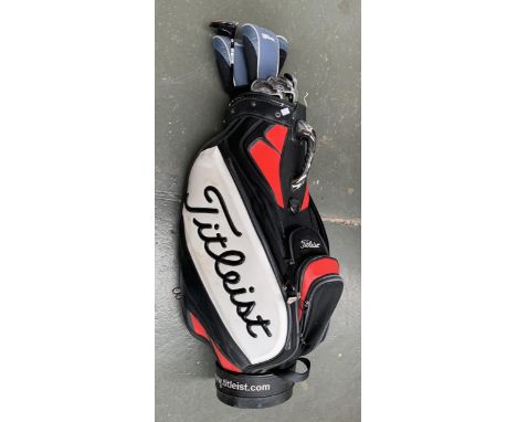 A Titleist golf bag containing a quantity of Dunlop and drivers clubs 