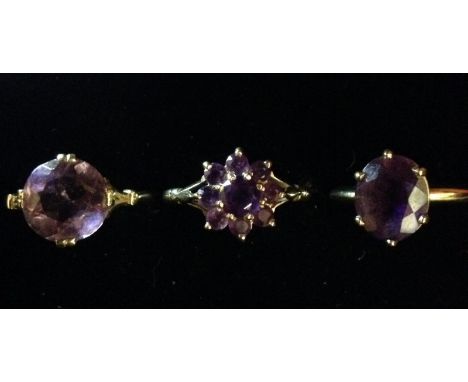 An amethyst floral cluster ring, central round amethyst raised above eight smaller stones, 9ct gold shank, size O;  an amethy