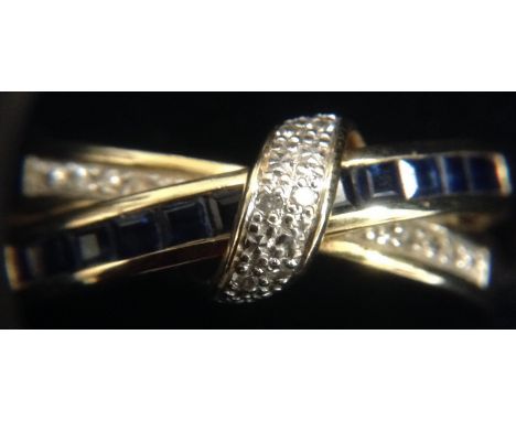 A sapphire and diamond ring, central arch encrusted with six diamond accents, above two crossing ribbons of twelve square cut