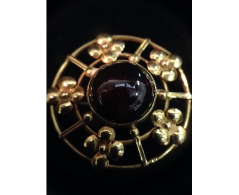 An amethyst target brooch, central round cabochon amethyst, surrounded by a five section open floral double ring yellow metal