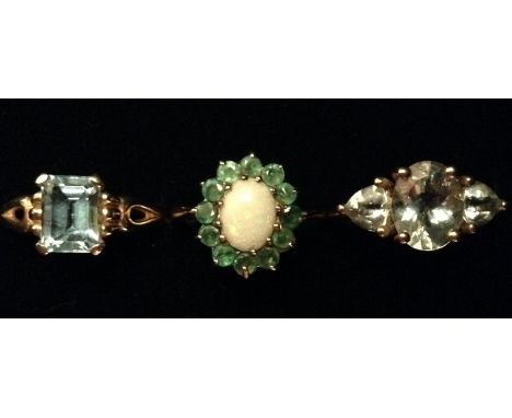 Rings - an oval emerald and opal cluster ring, central oval opal surrounded by a band of twelve round rough cut emeralds, 9ct