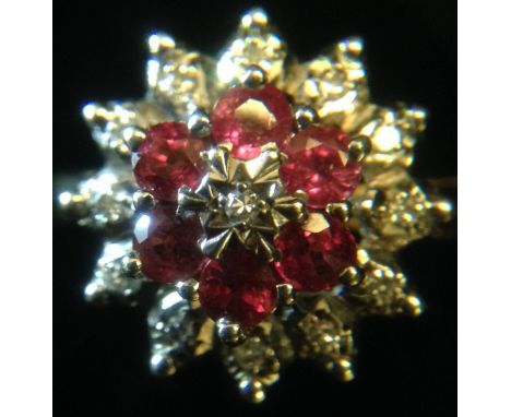 A ruby and diamond cluster ring, central diamond accent, surrounded by two stepped bands of six ruby's and twelve diamond acc