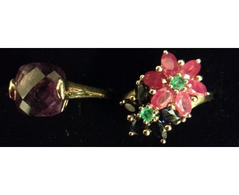 A ruby sapphire and emerald cluster ring, double interlaced flower head crest of a six oval rubies, and five oval sapphires, 