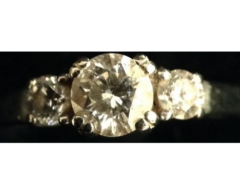 A diamond three stone ring, central round brilliant cut diamond, flanked by a pair of smaller conforming diamonds, total diam