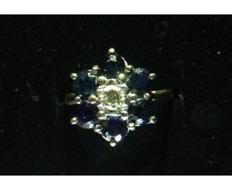 A diamond and sapphire flower head cluster ring, central round brilliant cut diamond, approx 0.16ct, surrounded by six round 