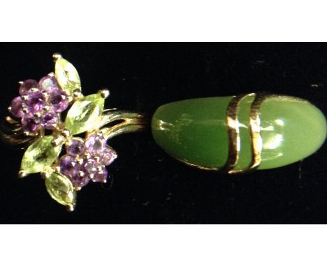 A peridot and amethyst floral cluster ring, two seven stone amethyst flower heads, divided by four oval leaf peridot's, open 