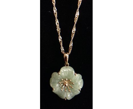A pale green jade flower pendant, five double arching petals surrounding a ten stamen centre, 9ct gold mount, suspended from 