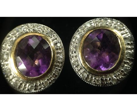 A pair of amethyst and diamond earrings, central oval amethyst surrounded by a pave band of diamonds, white and yellow gold m