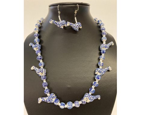 A 19" blue and white hand painted ceramic beaded necklace and matching earrings.  With giraffe shaped and spherical beads.  E