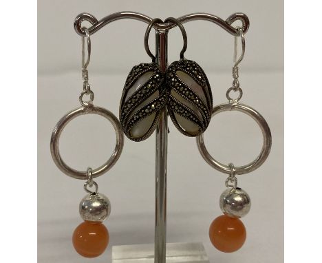 2 pairs of silver drop style earrings. A pair set with mother of pearl with marcasite set overlays.  Together with a hoop des