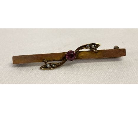 A vintage 9ct gold bar brooch set with a central round cut ruby &amp; 4 small seed pearls.  Marked 9ct to back.  Total weight