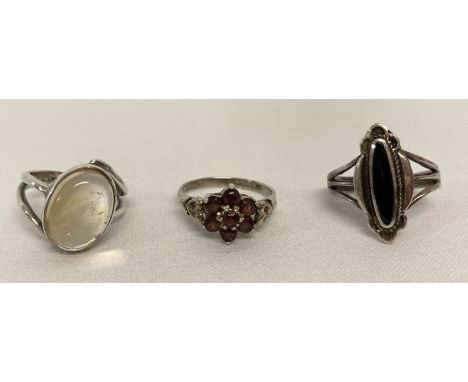 3 vintage stone set silver dress rings.  An oval cabochon of clear quartz, an oval of onyx in decorative mount and a flower h