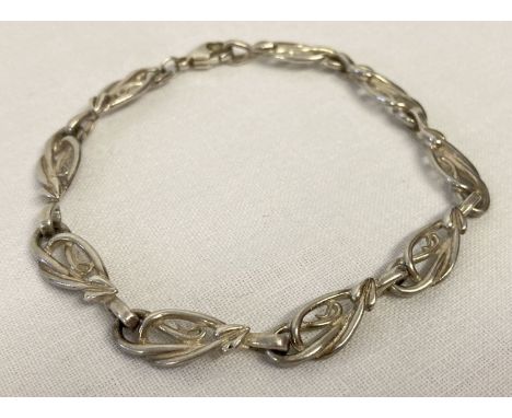 A decorative silver bracelet with Art Nouveau style links and lobster style clasp.  Back marked 925 with scales mark, claps m