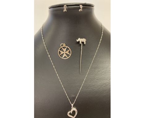 4 items of silver jewellery. A rhinoceros stick pin, a floating heart necklace, half hoop earrings  and a Maltese star pendan