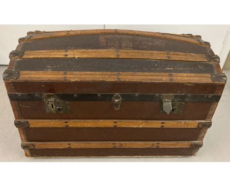 A Victorian dome top, wooden banded travelling trunk on metal casters.  Complete with original interior lift out tray and 2 k