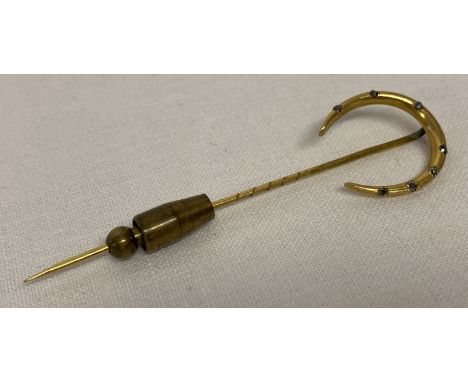 A vintage gold horseshoe stick pin set with 7 small round cut diamonds.  Horseshoe tests as 14ct, pin not gold. 