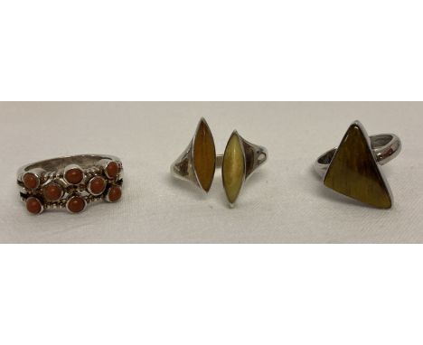 3 modern design silver dress rings set with natural stones. Comprising: tigers eye, two coloured amber and a red/brown agate.