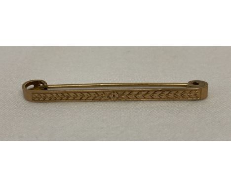 A 9ct gold tie pin with engine turned decoration to front. Marked 9ct to back with inscription.  "J.E.J. 1939".  Total weight