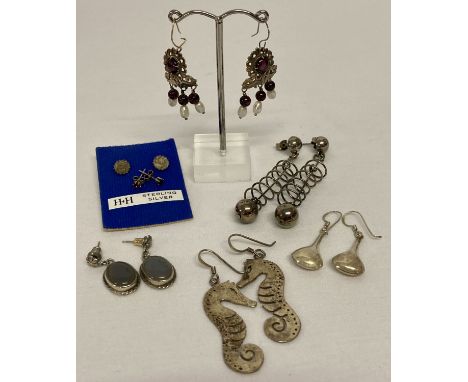 7 pairs of silver and white metal earrings in both drop and stud styles.  To include: seahorse shaped drops, decorative drops