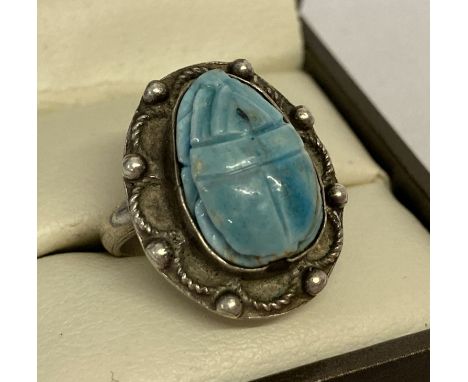 An Egyptian silver and turquoise ring carved in the shape of a scarab beetle.  Egyptian hallmarks to underside of surround an