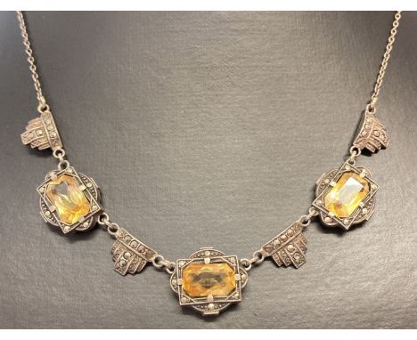 A vintage Art Deco style white metal necklace set with citrine and marcasite stones.  Set with 3 large emerald cut citrine st