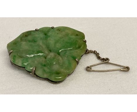 A vintage carved jade brooch in the from of a bat, with white metal mount and safety chain.   Approx. 3 x 3.5 cm.