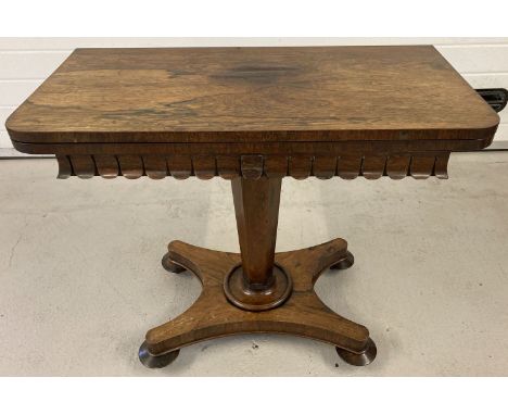 A Victorian walnut veneer games table with swivel and fold out top and fringed decoration.  Swivel top reveals a storage spac