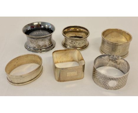 5 silver and 1 white metal vintage serviette rings.  Varying designs to include engine turned and floral. 