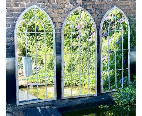 ARCHITECTURAL GARDEN MIRRORS, a set of three, aged metal frames, 160cm x 67cm. (3) 