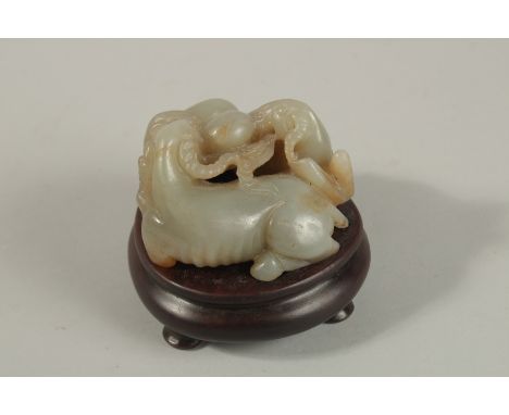 A CHINESE CARVED JADE GROUP DEPICTING THREE RAM'S, on a fitted hardwood stand, the base and stand with incised character mark