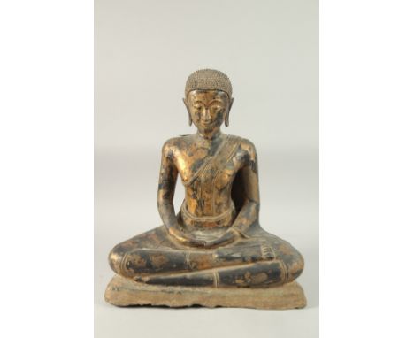 AN UNUSUAL LARGE THAI LACQUERED BRONZE SEATED BUDDHA, with gold leaf decoration and mounted to a heavy stone base, 59cm high.