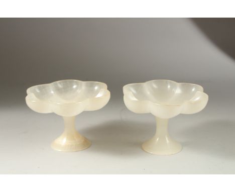 A PAIR OF NORTH INDIAN MUGHAL CARVED JADE PEDESTAL BOWLS, of lobed petal form, 15cm wide.