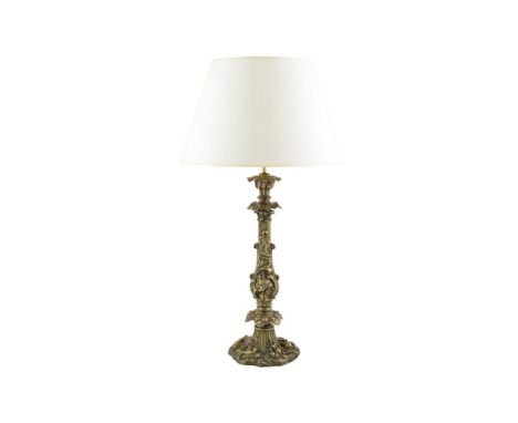 A CAST BRASS TABLE LAMP, the organic form column cast with foliate motifs, and raised on a shaped circular naturalistic sprea