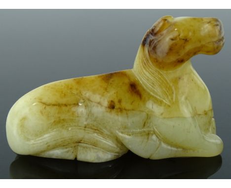 A Chinese carved white and russet jade recumbent horse, length 9cm.