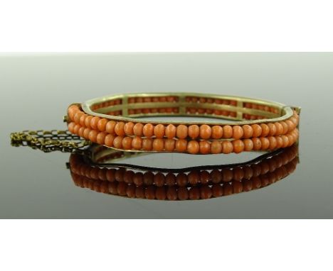 A Victorian double row coral hinged bangle, gilt metal settings, bangle diameter 53.3mm.