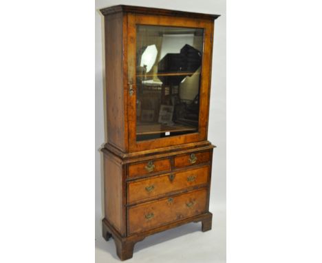 An 18th/19th century walnut cabinet on chest, of small size, single glass panelled door with 2 long and 2 short drawers below