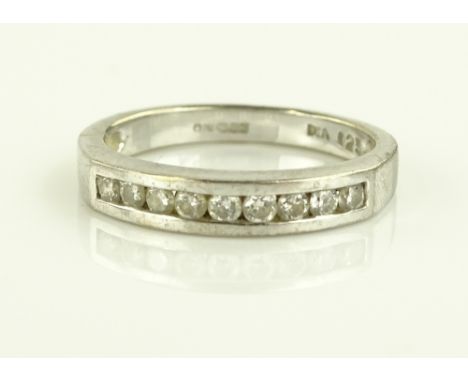 An 18ct white gold and diamond half eternity ring, total content of chanel set diamonds approx. 0.25cts, size K.